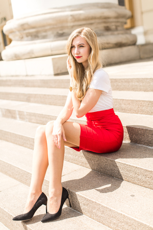 Young beautiful woman with long hair walking in cityの写真素材