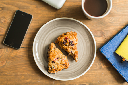 workplace with computer, notebooks, home-made cakes and coffeeの写真素材