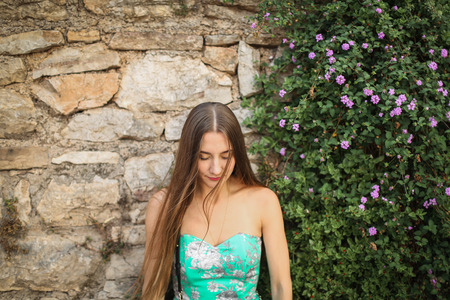 cute girl standing at the wall flowerの写真素材