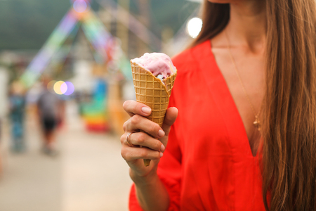 girl in amusement park eating ice creamの写真素材