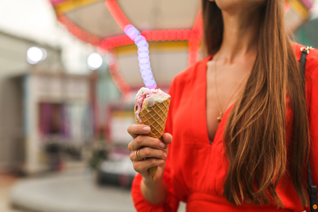 girl in amusement park eating ice creamの写真素材