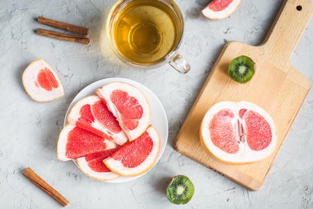 sliced grapefruit, kiwi fruit, cinnamon and teaの写真素材
