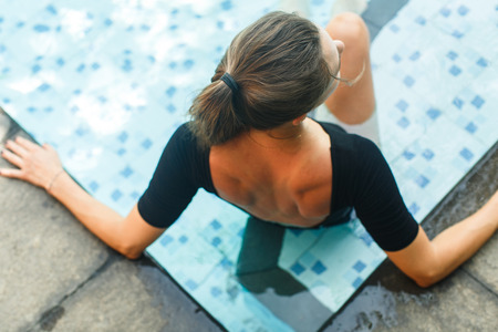 Girl resting in pool at the villaの写真素材