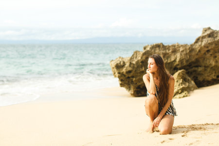girl walking near ocean and rocksの写真素材