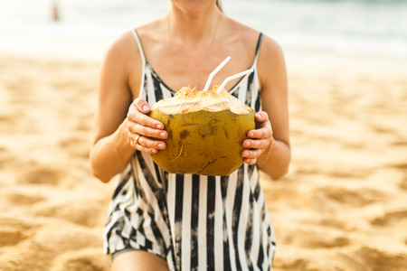 girl holds coconut in his handの写真素材