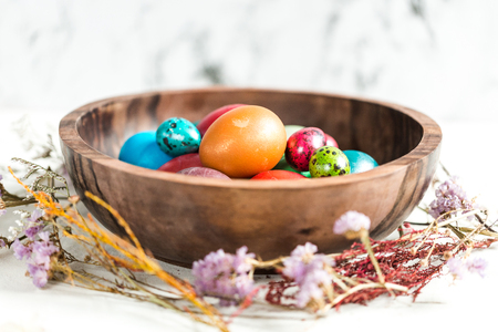 Dyed eggs in wooden plateの写真素材