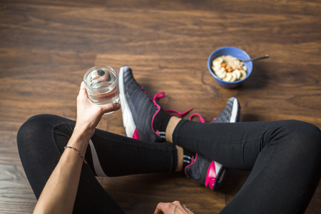 Fitness girl eating oatmeal porridgeの写真素材