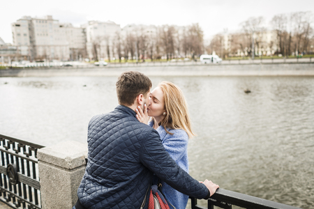Guy and girl embrace on the bridge backgroundの写真素材