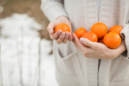tangerines in the hands of a girlの写真素材