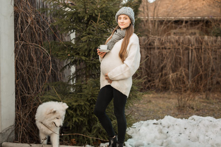 pregnant woman  in nature in autumn with cup of tea