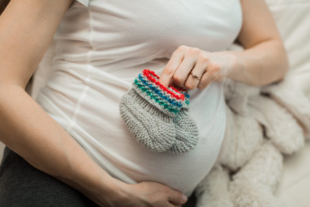 pregnant girl holding knitted booties