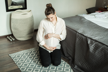 pregnant woman in bedroomの写真素材