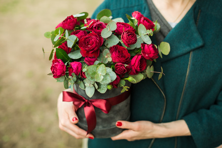 the girl is holding a bouquet of roses in her handsの写真素材