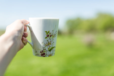 a cup of tea in his hand outdoors
