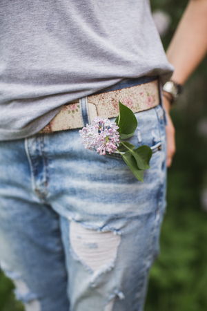 a branch of lilac in a jeans pocketの写真素材