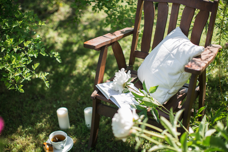 a wooden chair in the garden and a cup of teaの写真素材