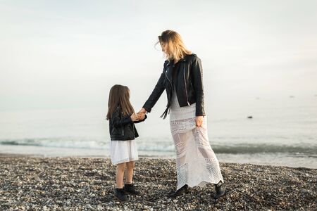 mother and daughter walking on the seaの写真素材