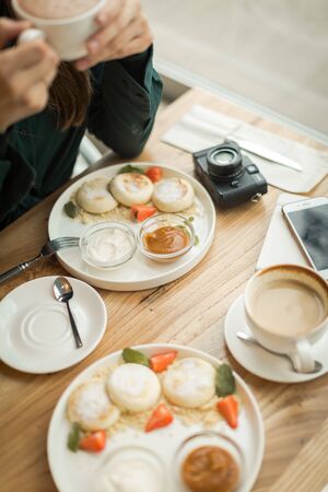young woman on a date at breakfast with a cameraの写真素材
