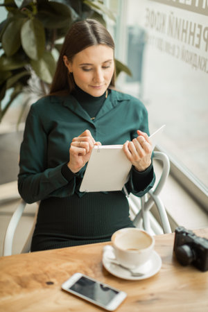 young girl in a meeting at breakfast with a notebook in the cafe