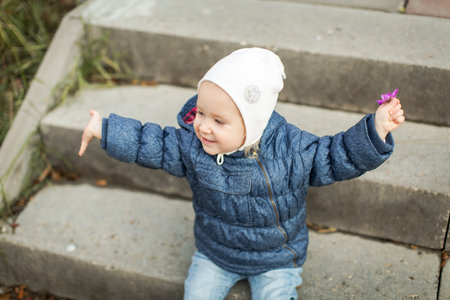 little child on a walk holds a flower