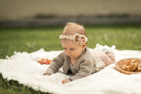 little girl lies on a plaid, summer picnic for children