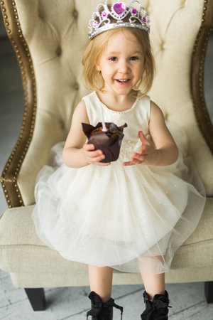 little princess celebrate her birthday. blows out the candle on the cakeの写真素材