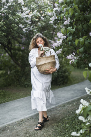 pregnant girl in the lilac garden with basketの写真素材