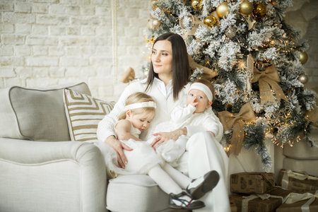 mother hugs her children, two happy sisters. holiday christmasの写真素材