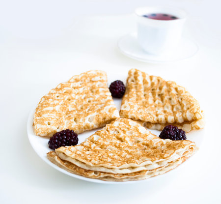 pancakes with blackberries on a white plate