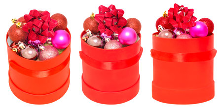 red round box with a red ribbon, inside multi-colored Christmas balls and a red bow