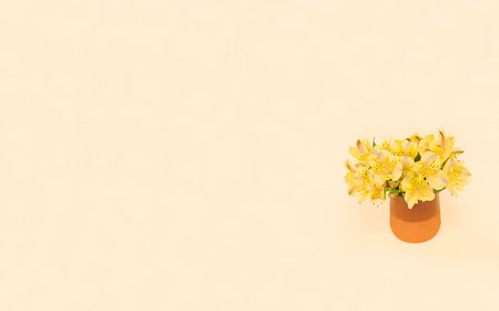 bouquet of yellow alstroemeria in a clay vase on a yellow background