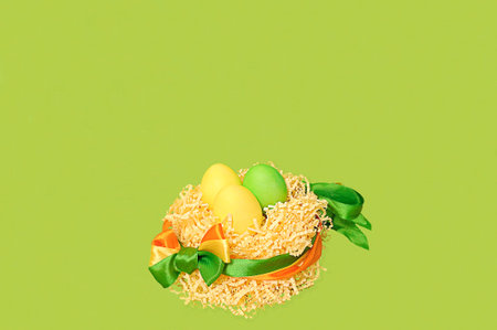 artificial nest made of cut paper with colored chicken eggs, tied with colorful ribbons