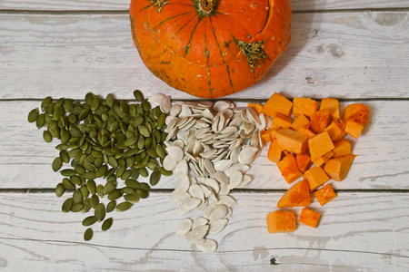 in front of the pumpkin with the top cut off are pumpkin seeds and pumpkin pulp, neatly arranged.の写真素材