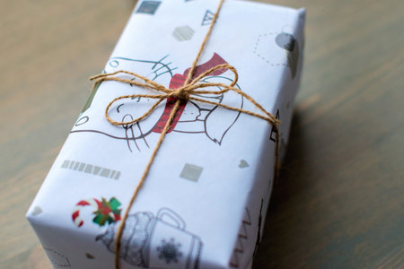 gift in New Years wrapping, tied with a rope. Christmas present. A piece of paper