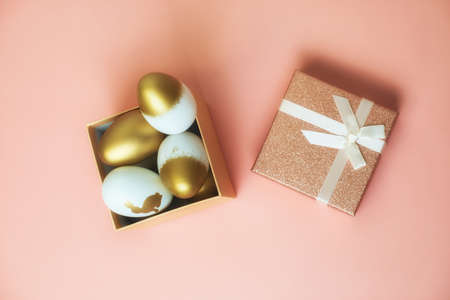 Festive Easter eggs in a gift box. pink background.の写真素材
