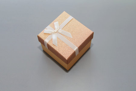 gift pink box with white ribbon and bow-knot on gray background
