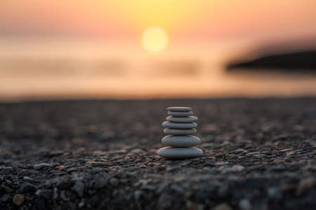 pyramid of stones by the sea at dawn. balanced zen stones.の写真素材