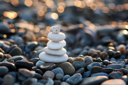 A figure of white stones on the seashore in the rays of the setting sun. Zenの写真素材