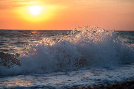 Sunset at sea, waves in the rays of sunsetの写真素材