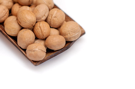 walnuts in a wooden bowl on a white background. isolate
