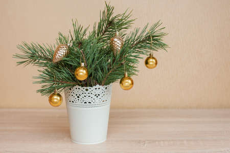 Small Christmas tree in a white bucket decorated with Christmas balls on the tableの写真素材