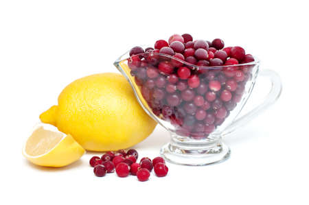 frozen cranberries in a cup and lemon on a white background. Natural vitaminsの写真素材