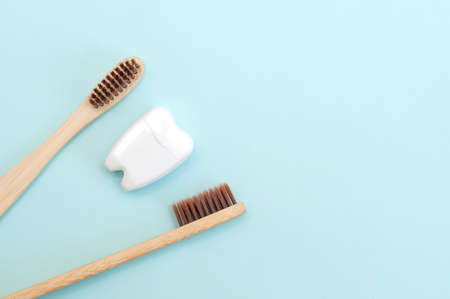 Bamboo toothbrushes and a white tooth on a blue background. Place for text. Backgroundの写真素材