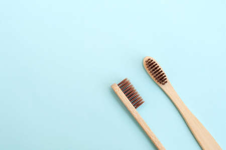 Two bamboo toothbrushes on a blue background. Place for text. Backgroundの写真素材