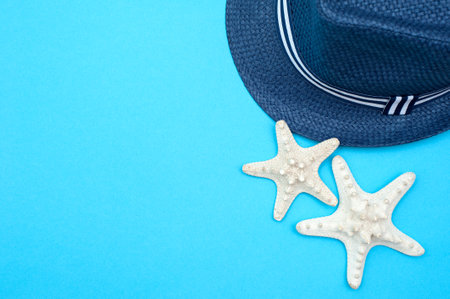 Travel background. Beach hat and starfishes on a blue background.の写真素材