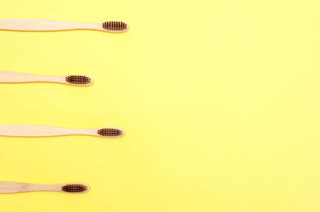 Bamboo toothbrush on a yellow background. Dental care. Copy spaceの写真素材