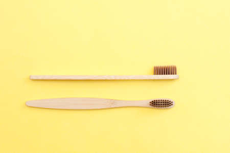 Bamboo toothbrush on a yellow and blue background. Dental care.の写真素材