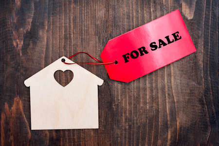 Miniature house with a red sign for sale. Real estate purchase, property insurance, cute house ecology rental conceptの写真素材