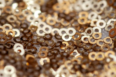 Texture of gold sequins on a white fabric. Selective focus