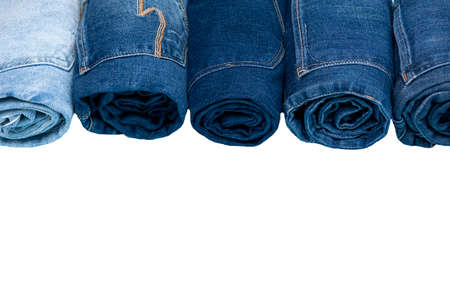 Row of assorted rolled up jeans isolated on white background. View from aboveの写真素材